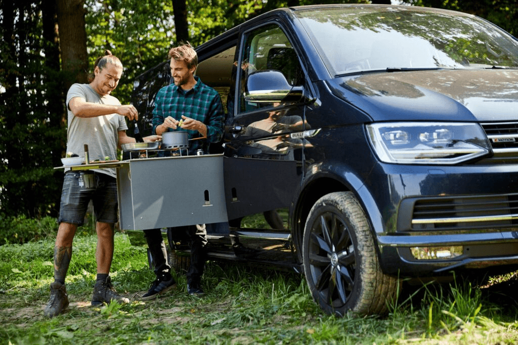 Camptools Zwei Personen Auto Zwei Personen mit Camptools-Ausrüstung am Auto