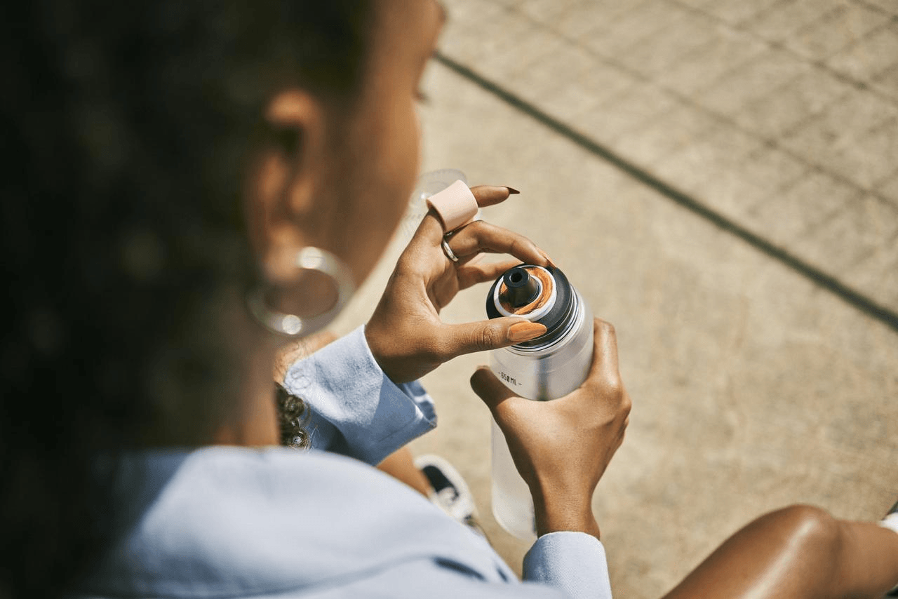 Frau mit air up Flasche Frau trinkt aus einer air up Flasche