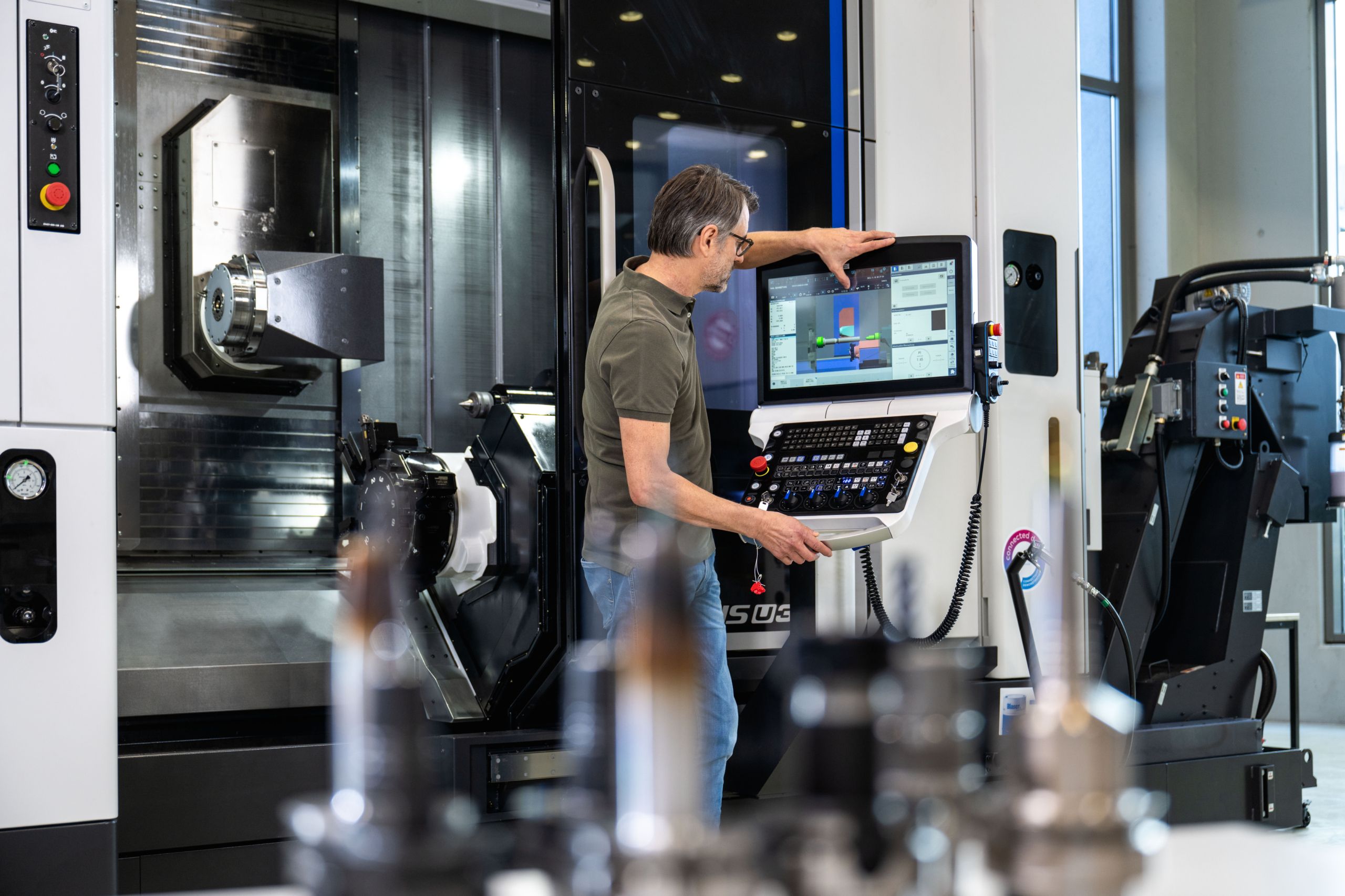 Mann arbeitet an einer Maschine – Bechtle PLM